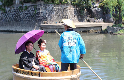 結婚式のイベント演出。大垣の水門側を、たらい舟で川下りする新郎新婦。
