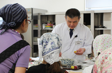 「粋料亭　助六」料理長が、親子に対して和食の料理方法を教える様子